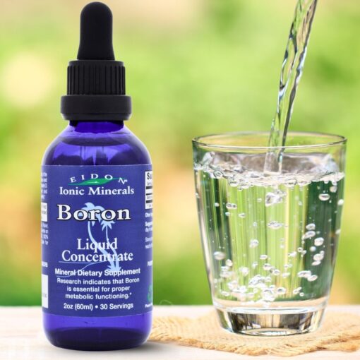 Flaske med Eidon Ionic Minerals Boron Liquid Concentrate (60 ml) ved siden av et glass vann som fylles
